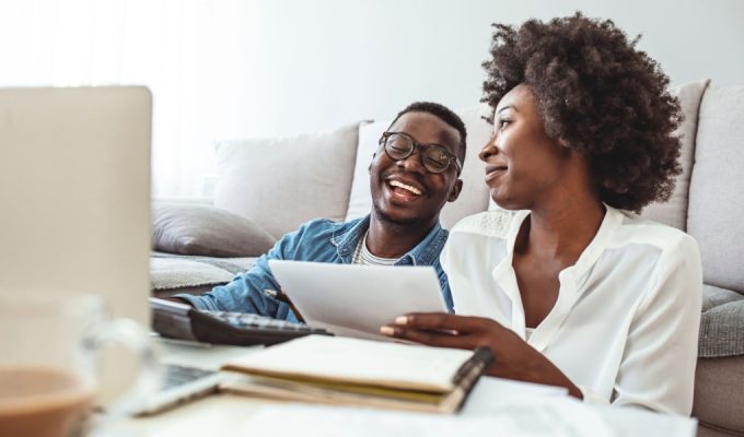 Young married couple doing their paperwork together, paying bills online.