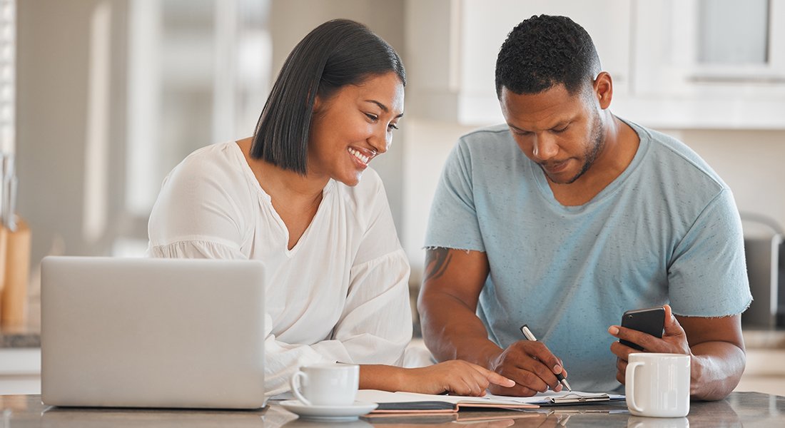 Married Black couple reviewing their mid-year financial goals.
