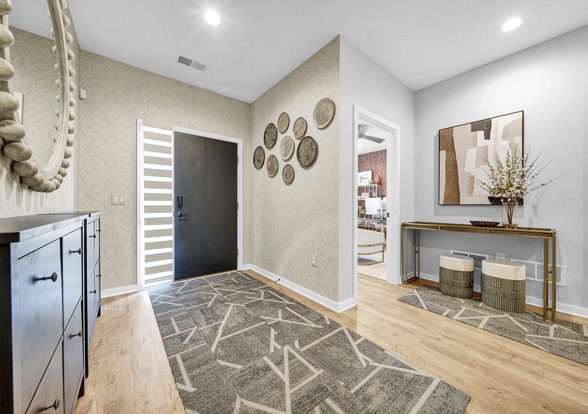 You can create culture in the home as this entryway was designed as an immediate cultural experience, layered with a bold tribal-inspired wallpaper, a patterned runner, wood and ceramic wall décor.