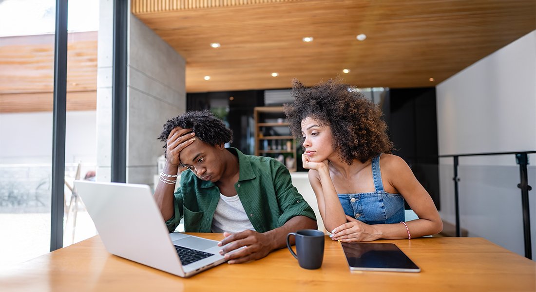 Young Black couple going over finances. He is a saver and she is a spender.
