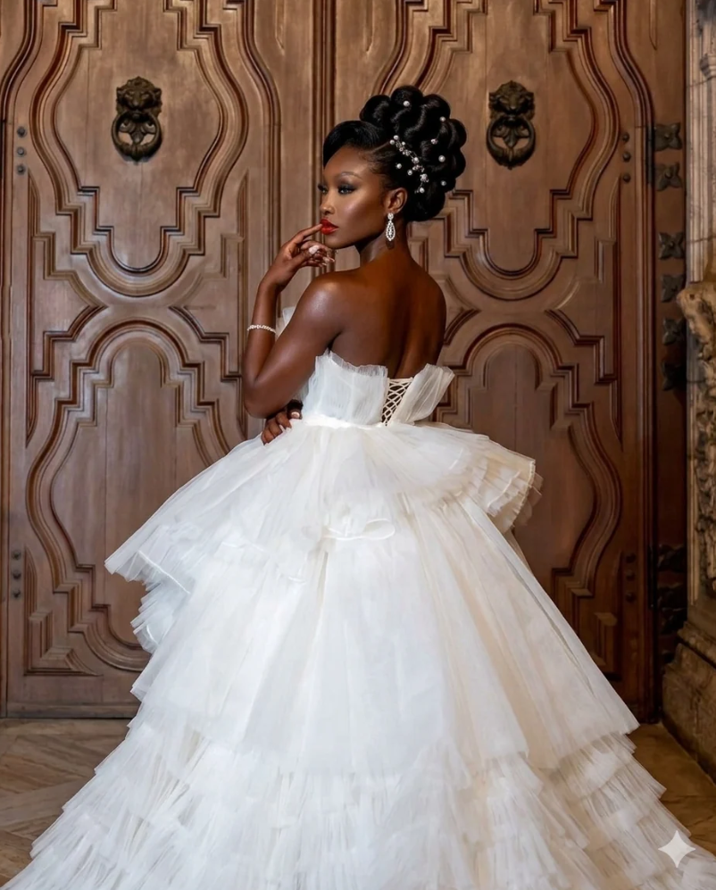 Bridal designer Ugochi Iwuaba designed the Royal Serenity Ruffle Gown for the bride who believes grandeur should still feel graceful. Crafted with a structured corset bodice and cascading tiers of voluminous tulle, this gown creates movement that feels both dramatic and weightless.